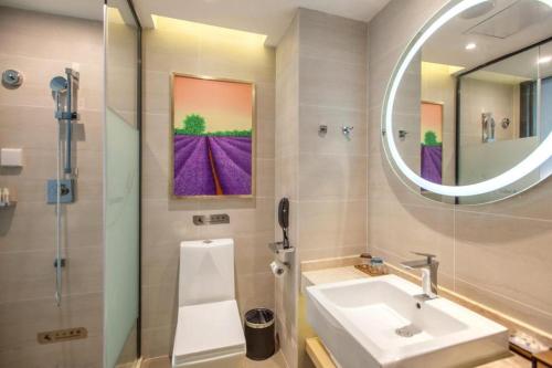 Lavande Hotel Wuhan Hanjiang Road Liuduqiao Metro Station في ووهان: حمام مزود بحوض ومِرآة