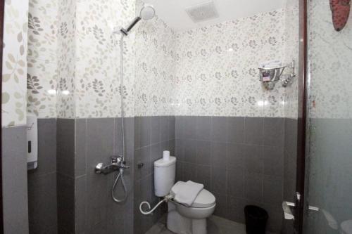 a bathroom with a shower with a toilet at Oriza Hotel Surabaya in Surabaya