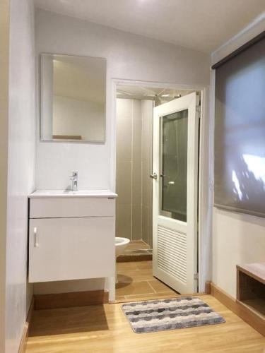 a white bathroom with a sink and a shower at THE GOOSE HOUSE UBON in Ubon Ratchathani