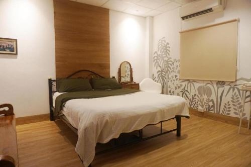 a bedroom with a bed and a chalkboard on the wall at THE GOOSE HOUSE UBON in Ubon Ratchathani