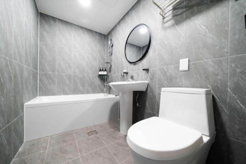 a bathroom with a toilet and a sink and a mirror at Chuncheon World Hotel in Chuncheon