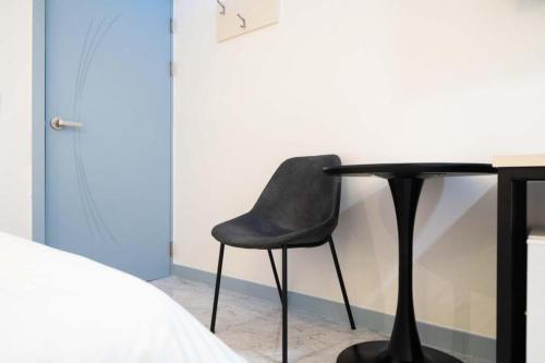 a black chair sitting next to a desk in a bedroom at Chuncheon World Hotel in Chuncheon