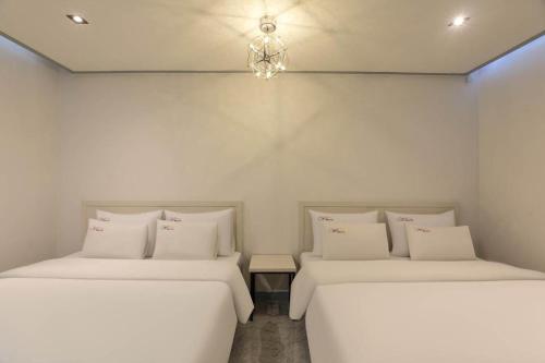 two beds sitting next to each other in a room at Chuncheon World Hotel in Chuncheon