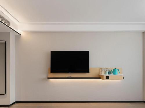 a flat screen tv on a white wall at City Comfort Inn Nanning Guangxi University in Nanning