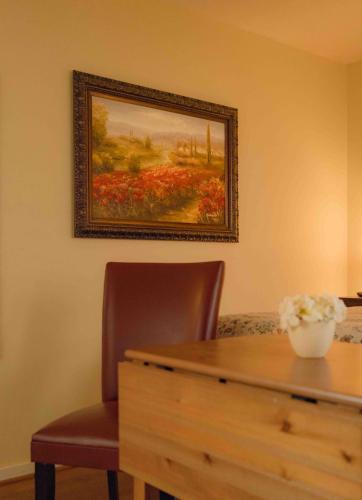 a painting on a wall with a table and a chair at Cabernet House, an Old World Inn in Napa