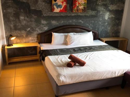 a bedroom with a large bed with a wooden headboard at Sritrang Hotel in Trang