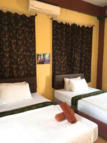 two beds in a hotel room with towels on them at Sritrang Hotel in Trang