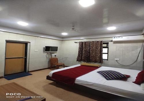 a bedroom with a large bed and a television at Hotel Geetanjali St Bus Stand Panvel in Panvel