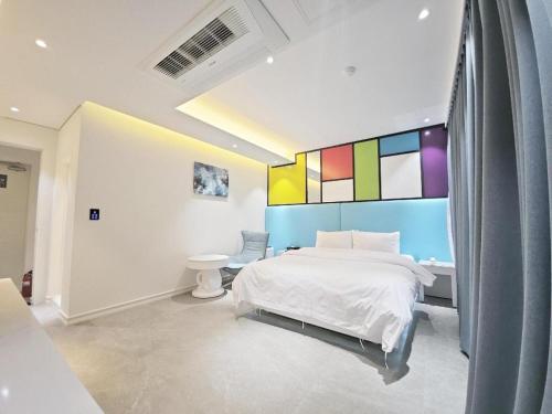 a bedroom with a bed and a colorful wall at Boutiquehotel K Ilsan in Goyang