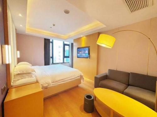 a hotel room with a bed and a couch at Lavande Hotel·Dongxing Port in Fangcheng