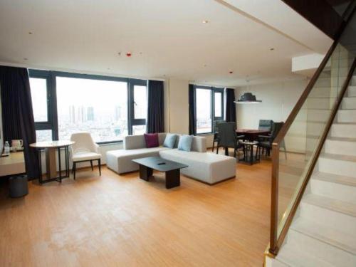 a living room with a white couch and a table at Lavande Hotel·Dongxing Port in Fangcheng