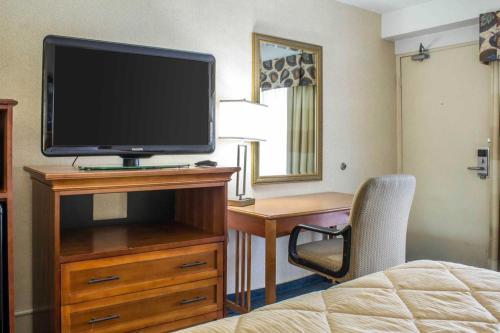 a hotel room with a television on a dresser with a bed at Lifestyle Inn Cedar Falls in Cedar Falls