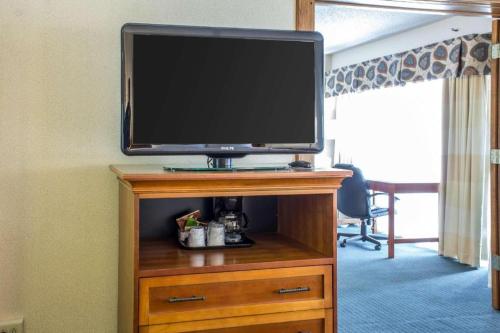 a flat screen tv sitting on top of a wooden entertainment center at Lifestyle Inn Cedar Falls in Cedar Falls