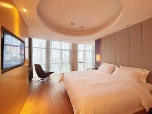 a bedroom with a large white bed and a tv at Lavande Hotel·Dongxing Port in Fangcheng