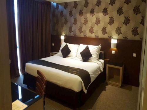 a bedroom with a large bed in a hotel room at Ratu Hotel Serang in Serang