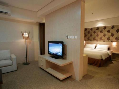 a hotel room with a television and a bed at Ratu Hotel Serang in Serang