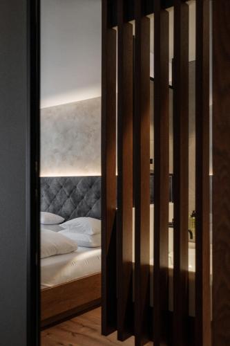 a door to a bedroom with a bed with white pillows at Hotel Alte Post Südsteiermark in Leibnitz