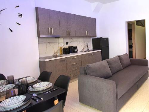 a living room with a couch and a kitchen at GIOLANDA PATRASSO - Modern apartment in the center of Patras in Patra