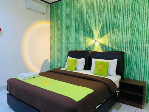 a bedroom with a bed with a green wall at Hotel Huswah Airport in Jakarta