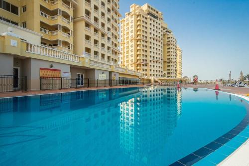 a large swimming pool in a building with tall buildings at Serene Lagoon Escape in Ras al Khaimah