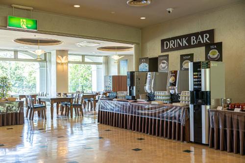 a restaurant with tables and chairs and a drink bar at GARDEN HOTEL Hanayo in Tanabe