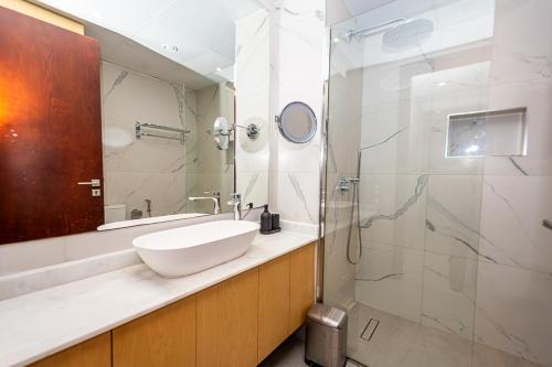 ein Badezimmer mit Waschbecken und Dusche in der Unterkunft Serene Lagoon Escape in Ras al Khaimah