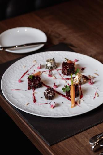 a white plate with some food on a table at Hotel Alte Post Südsteiermark in Leibnitz
