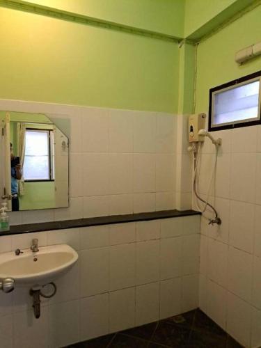 a bathroom with a sink and a mirror at At Home Suanphung in Ratchaburi