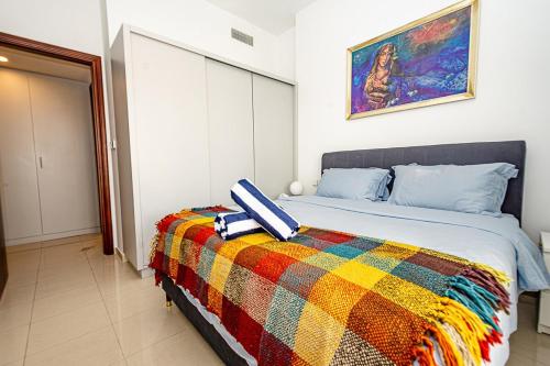 ein Schlafzimmer mit einem Bett mit einer bunten Decke in der Unterkunft Serene Lagoon Escape in Ras al Khaimah