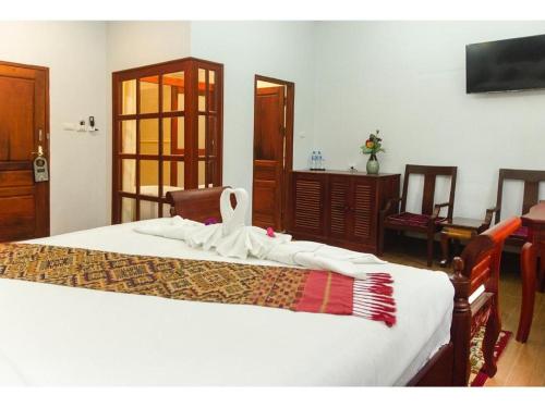 a bedroom with a bed with a towel on it at The View Pavilion Hotel in Luang Prabang