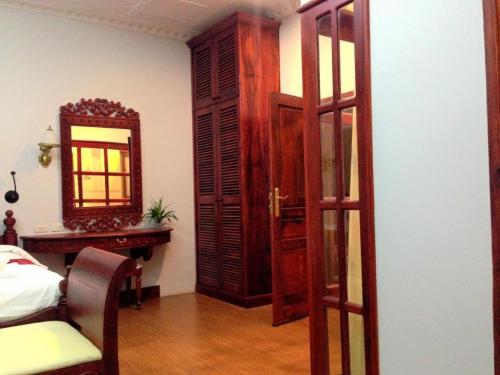 a room with a bedroom with a mirror and a bed at The View Pavilion Hotel in Luang Prabang