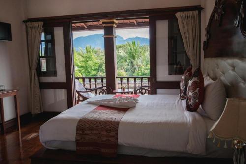 a bedroom with a bed and a large window at The View Pavilion Hotel in Luang Prabang