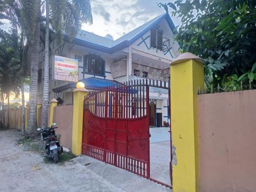 a red gate in front of a house at Shore Manor in Supa