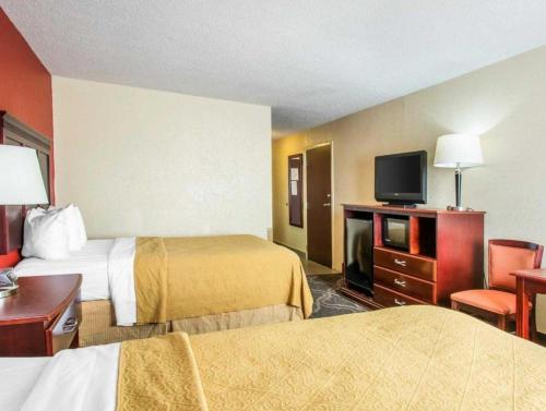 a hotel room with two beds and a flat screen tv at Quality Inn Prattville I-65 in Prattville