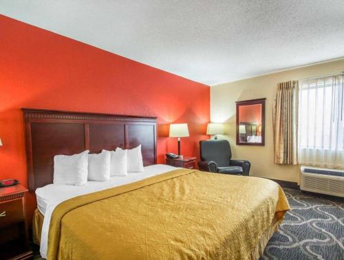 a hotel room with a bed and a chair at Quality Inn Prattville I-65 in Prattville