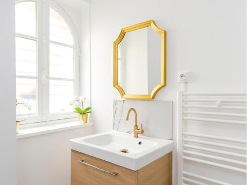 a bathroom with a white sink and a mirror at Merveil - Family Suite - Opera - Mauroy II in Paris