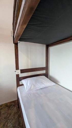 a bed in a room with a white bedsheet at Gokanna Pearl Guest & Hostels in Trincomalee