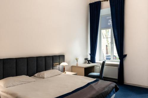 a bedroom with a bed and a chair and a window at Metro Hotel Apartments in Odesa