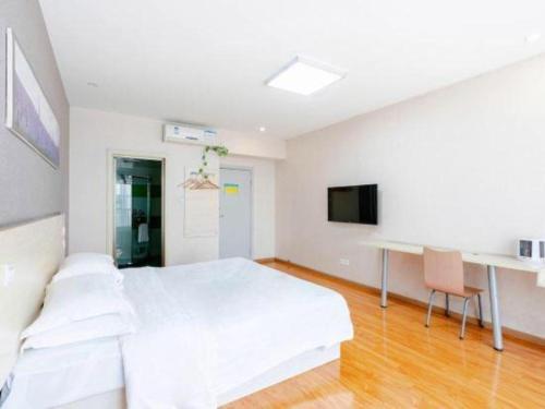 a white bedroom with a bed and a desk at 7 Days Inn Chengdu Huayang Metro Station Binfen Plaza in Chengdu