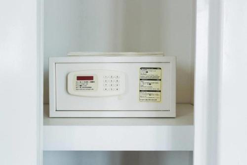 a white microwave sitting on a shelf in a kitchen at Hotel Zing Phnom Penh in Phnom Penh
