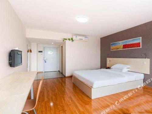 a bedroom with a white bed and a television at 7 Days Inn Chengdu Huayang Metro Station Binfen Plaza in Chengdu