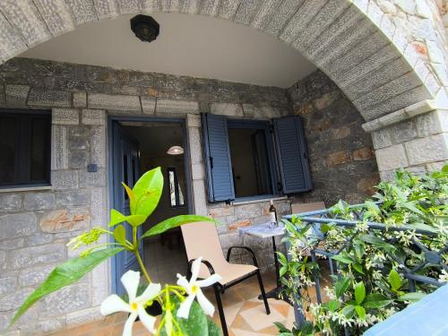 a patio with a table and chairs and some plants at Taletos Apartments in Stoupa