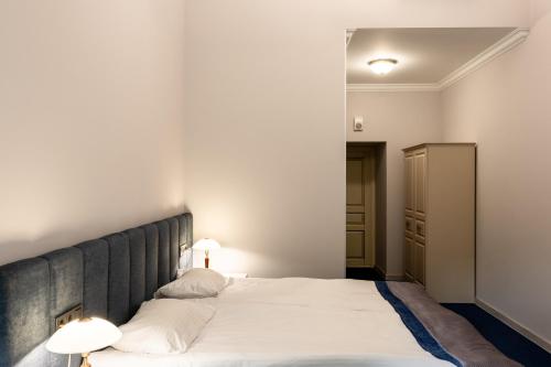 a bedroom with a large white bed with two lamps at Metro Hotel Apartments in Odesa