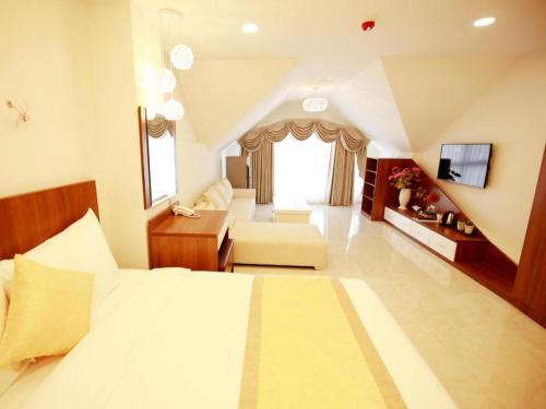 una grande camera da letto con un letto e un soggiorno di Kim Hoa Hotel a Da Lat