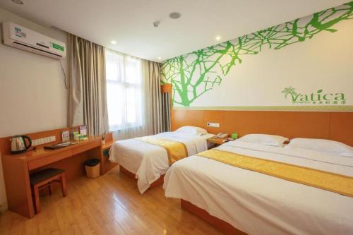 a hotel room with two beds and a desk at Vatica Tianjin Jinghai Bus Station Home World Plaza Hotel in Tianjin