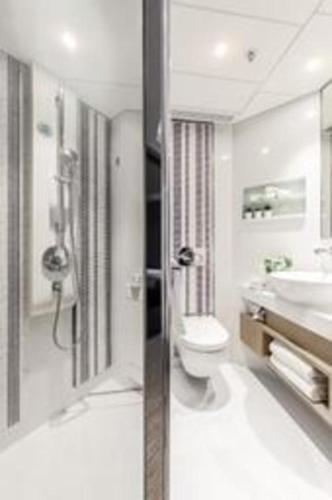 a bathroom with a toilet and a sink at Elysion Place Hotel Causeway Bay in Hong Kong