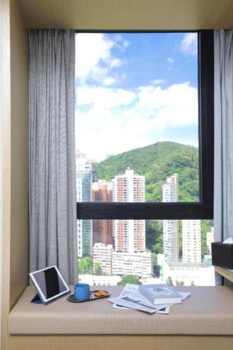 a window with a view of a city at Elysion Place Hotel Causeway Bay in Hong Kong