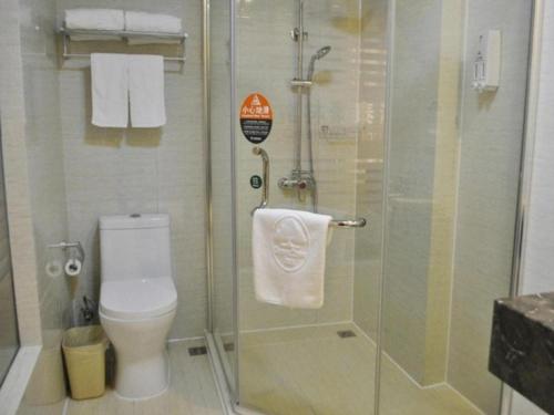 a bathroom with a toilet and a glass shower at GreenTree Inn Yancheng Economic Development Zone Management Committee Express Hotel in Ti-pa-yung