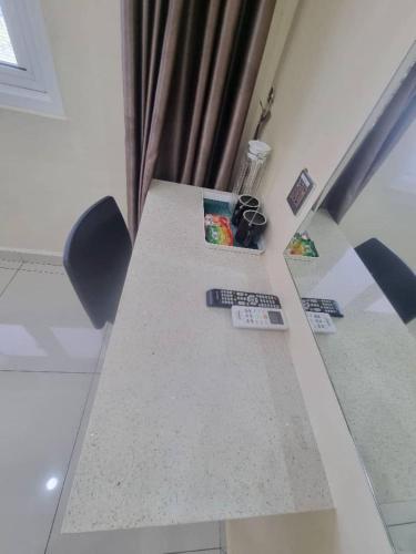 a table with three remote controls on top of it at Avatel Jelutong in George Town