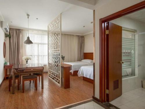 a hotel room with a bed and a desk and a bedroom at GreenTree Inn Yancheng Economic Development Zone Management Committee Express Hotel in Yancheng